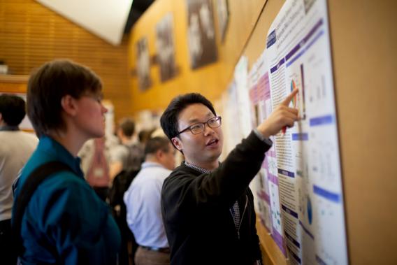 Two people looking at poster at Cold Spring Harbor Laboratory "The PARP Family and ADP-ribosylation" Meeting, 2014