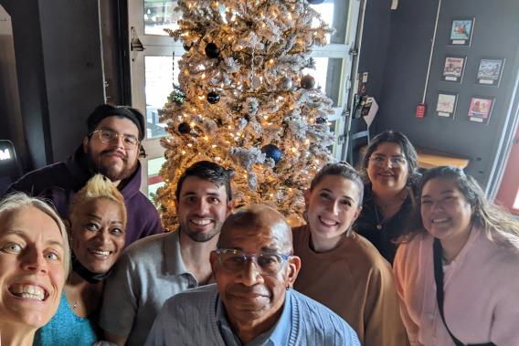 Nijhawan Lab standing in front of a golden decorated christmas tree