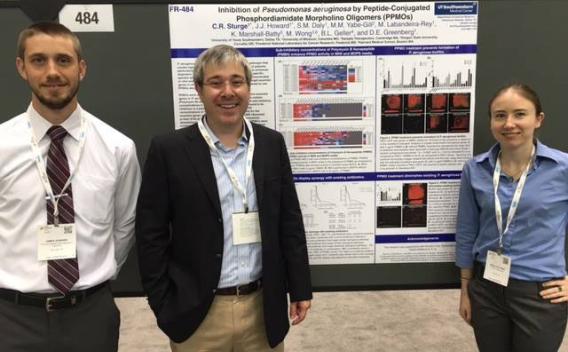Lab members standing in front of poster presentation