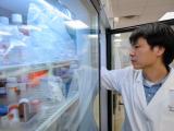 Burstein Lab member reaching into fridge