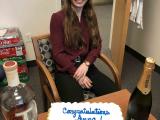 Anna passed her quals! Anna sitting with cake, whiskey and champagne