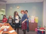 Team members watch as Olga belly is measured at her Baby Shower