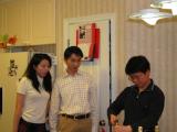 Three team members in office opening bottle of champagne