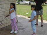 Two children in park holding badminton rackets