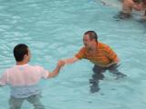 Two team members in pool (one dressed)