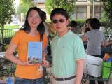 Two team members at pool party with book