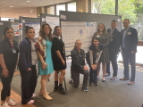 team standing near poster presentation